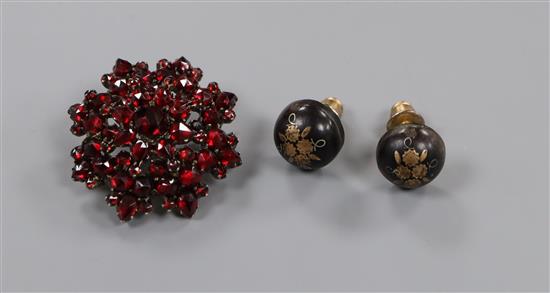 A pair of Edwardian tortoiseshell pique ear studs and a yellow metal and garnet set brooch.